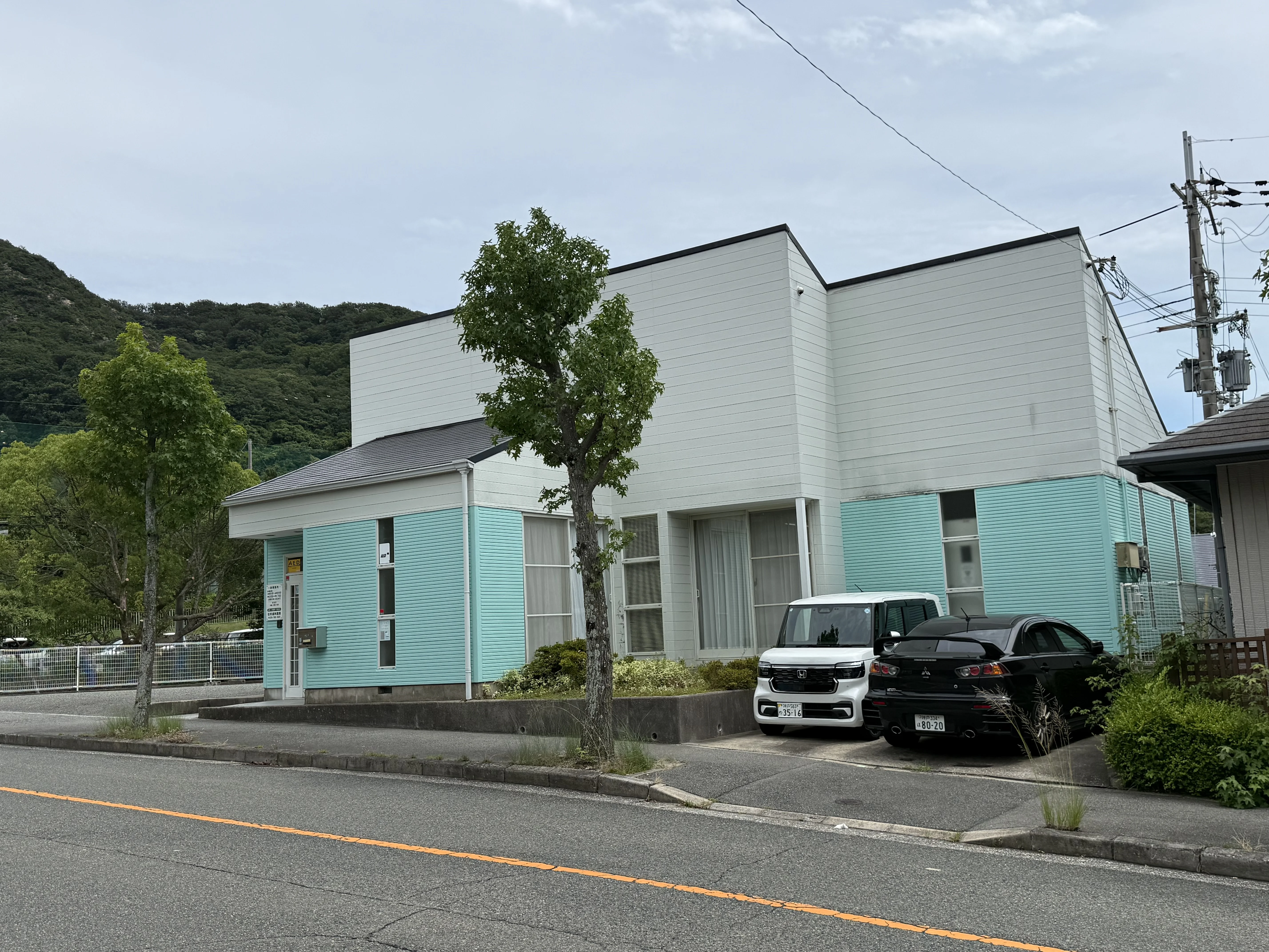 医院の建物と駐車場が並ぶ杉村歯科医院の外観
